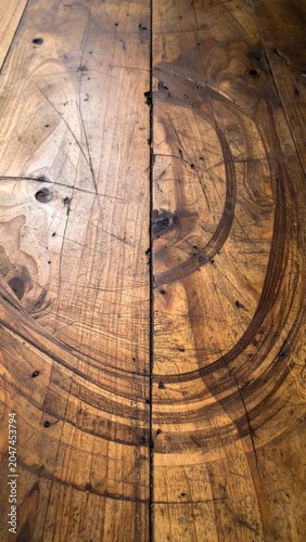 Rustic Wooden Plank Surface with Circular Grain Patterns and Scratches