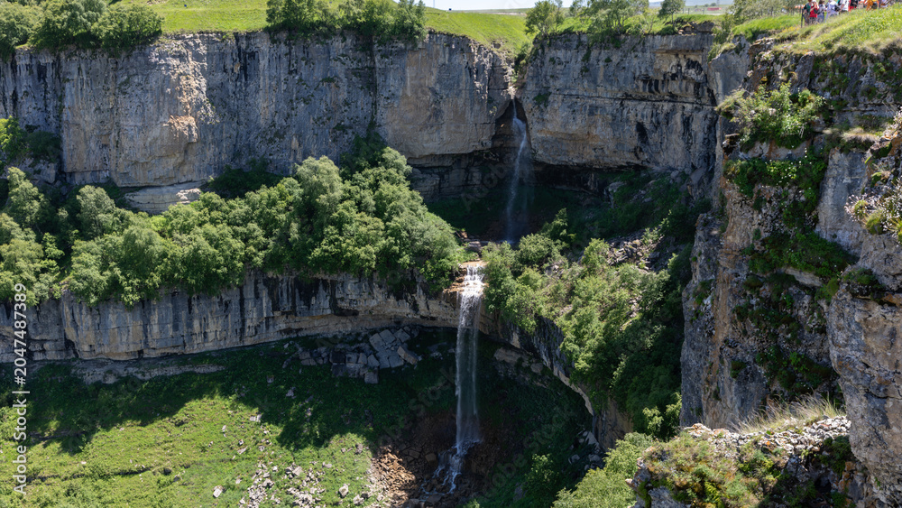Fototapeta premium Scenic view of Matlas Waterfalls dropping into a deep limestone canyon near Matlas village, Khunzakhsky District, Republic of Dagestan, Russia on a sunny day