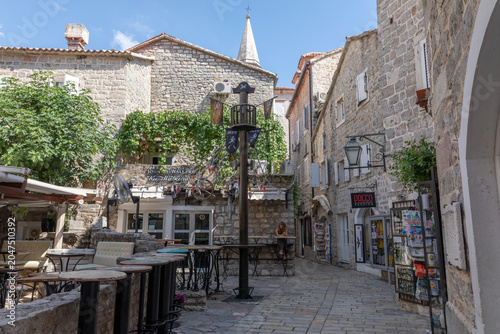 Foto Budva, Montenegro - August 3, 2025: Sunny pedestrian lane with stone houses, out