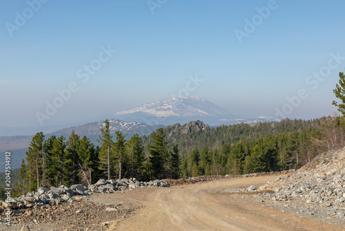 Bild auf Leinwand Wide panoramic view of Konzhakovsky Stone mountain with lingering snow patches a