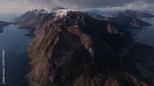 Aerial view of snow‑capped coastal mountains and fjord under overcast sky