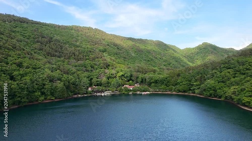 山間に広がる静かな湖と新緑が織りなす初夏のドローン映像素材