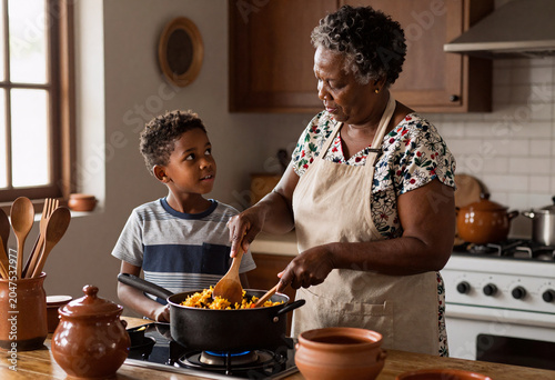 African American Grandmother Teaching Grandson Jollof Rice