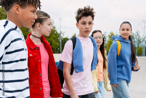 Photos Diverse group of teenagers walking together in casual clothing