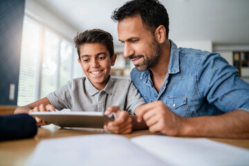 Father and son using tablet and doing homework