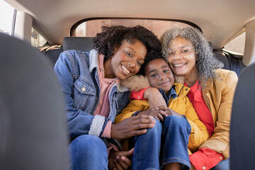 Smiling multi-generation family sitting together in car
