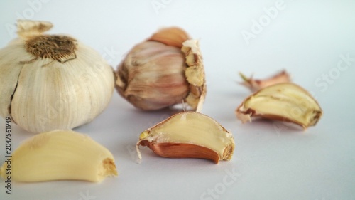 Fotografie These are whole cloves of garlic, and some cloves that have been partially or completely peeled and placed on a white background