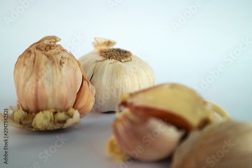 Foto These are whole cloves of garlic, and some cloves that have been partially or completely peeled and placed on a white background