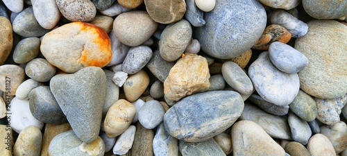 Canvas Print High-contrast shot of dark and light river stones, creating a striking natural m