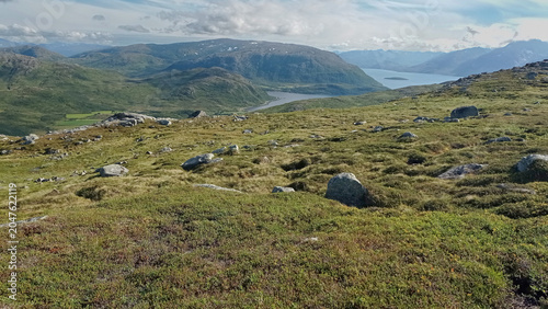 Panoramic view of Arctic tundra landscape and fjords from Nattmalsfjellet mountain in Kvaloya Island, Tromso, Northern Norway. Hiking trail view over majestic hills near Tromso region.