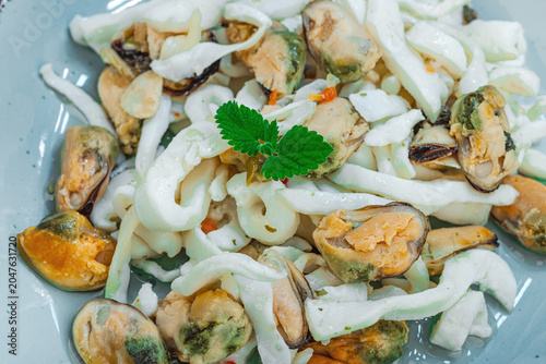 Healthy seafood cocktail salad featuring mussels and squid with starfish and seashells decoration