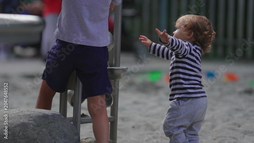 Canvas-taulu Toddler briefly losing balance before reaching playground activity structure wit