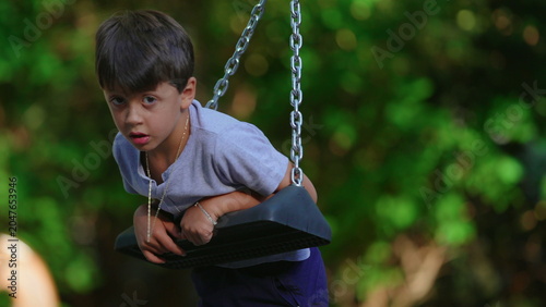 Εκτύπωση καμβά Boy rotating on playground swing during outdoor playtime capturing motion, freed