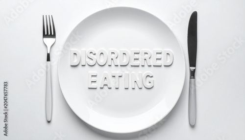 Concept of Disordered Eating Spelled Out on Dinner Plate with Fork and Knife