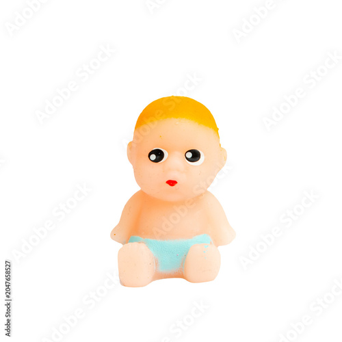 Cut out Small rubber baby doll isolated on a black background. Cute tiny plastic baby toy sitting on solid black surface, close-up view. PNG.
