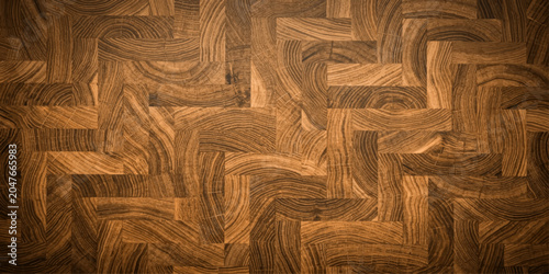 A detailed close-up shot showcases the intricate grain patterns and rich, warm tones of a parquet wood floor, highlighting the natural beauty and craftsmanship of the material.