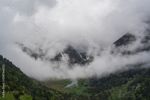 Green forests and mist on steep mountain slopes, surrounded by nature.