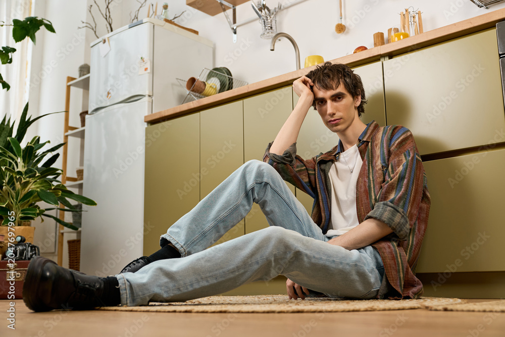 Fototapeta premium Androgynous young man embodies authenticity while enjoying a relaxed day at home