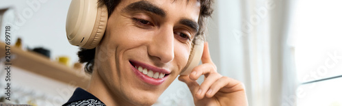 фотографія Androgynous young man enjoying music at home with a sense of freedom and express