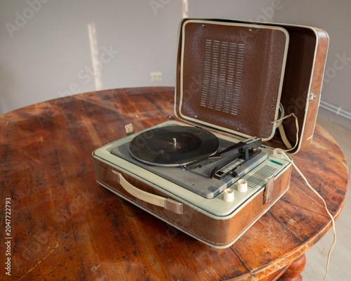 Bild auf Leinwand Vintage record player on a rustic round table, open lid.