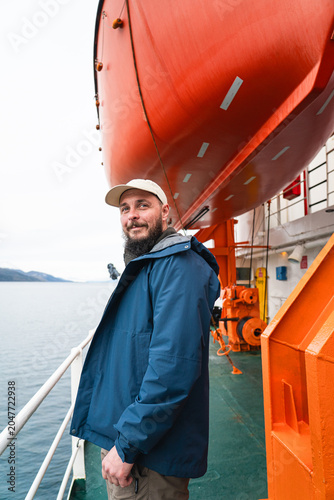 Antarctic tourism. Tourist on a ship during Antarctic expedition looking at the landscape in the background