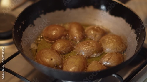 Potatoes are fried in melted butter in a pan