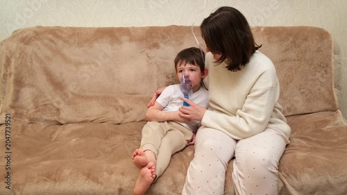 Woman and child using nebulizer for inhalation treatment. Mother helping son with respiratory illness home therapy. Medicine for asthma.