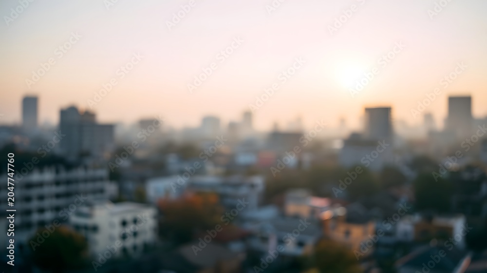 Fototapeta premium A soft blurred cityscape background illuminated by warm sunrise or sunset light creates a tranquil and inviting urban atmosphere