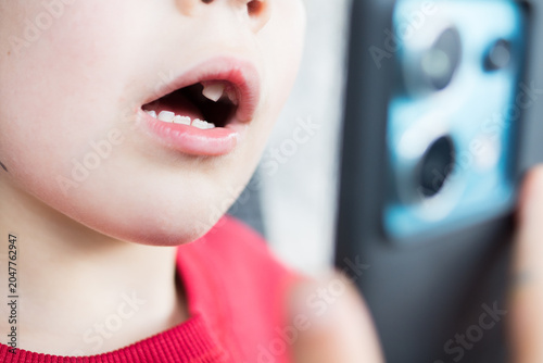 Foto Pediatric teledentistry concept with child and mobile phone