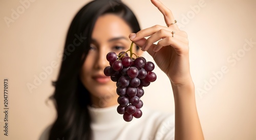 Woman holding a bunch of fresh purple grapes