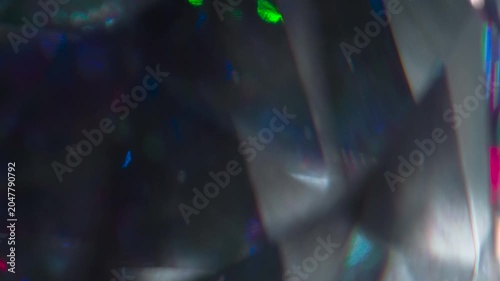 Diamonds Facets Shimmer in the Dark. The light passes through the facets of a slowly rotating diamond and creates repetitive sparkling highlights and rainbow colors