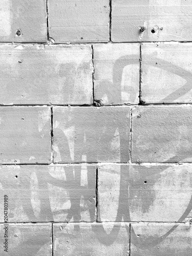 Grayscale Brick Wall with Faded Graffiti