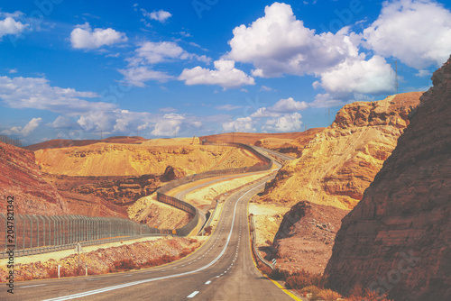 Driving a car on mountain Israel road. Desert landscape. Empty road. The road runs along the border of Israel with Egypt. View from the car of the mountain landscape on a sunny day. Israel