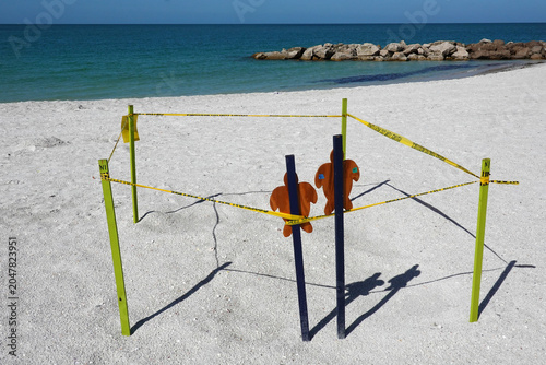Fotografi A designated turtle nesting area bordered by yellow stakes and caution tape