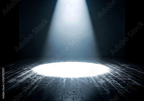 A spotlight shining down on a dark stage with a bright white light