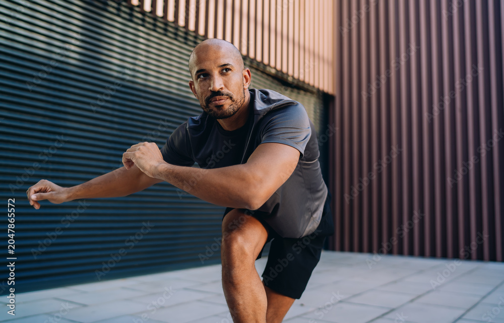 Fototapeta premium Handsome sportive man in athletic wear doing workout exercise, athlete enjoying an outdoor run session in city, fitness motivation and urban wellness