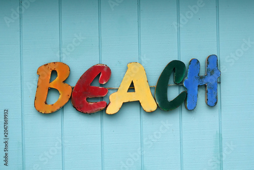Konstfotografi Multicolored letters spelling BEACH are affixed to a light blue wooden wall
