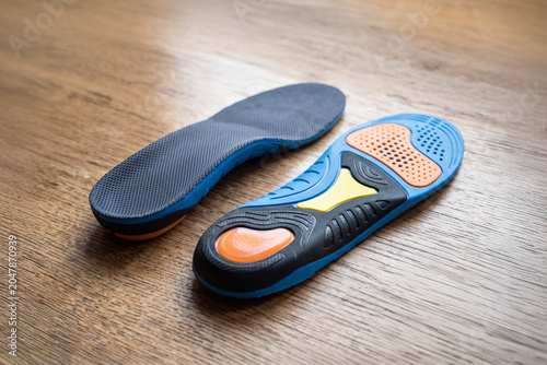 Ergonomic running insoles with shock absorption on wooden background