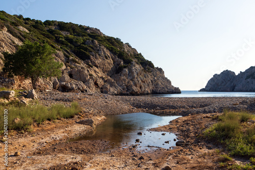 Remote paradise cove of Avlonia beach with pebble coast on Chios island