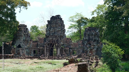 A wide-angle, eye-level photograph of the historic, partially ruined temple structures at Preah Khan of Kampong Svay, Cambodia, taken on June 5, 2025, as seen in The image captures the weathered sands