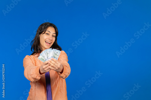 Young woman showing cash money representing earnings