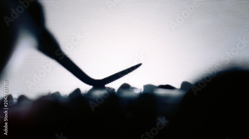 Dental hygienist cleaning tartar oral hygiene tooth scale dental tool silhouette shadow white wall high contrast abstract concept sunlit texture