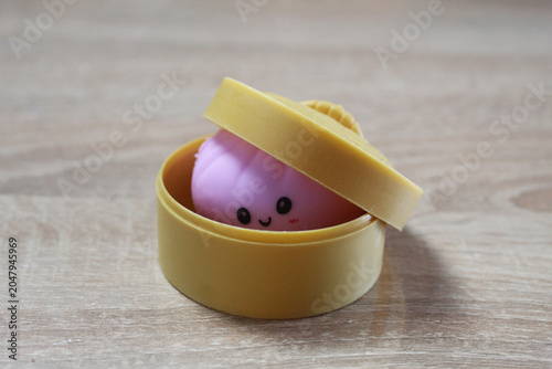 Pink Anti-Stress Squash squishy Dumpling Lying In Yellow Case