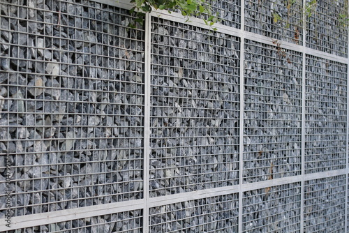 Foto Modern gabion wall construction with rough stones and metal grid
