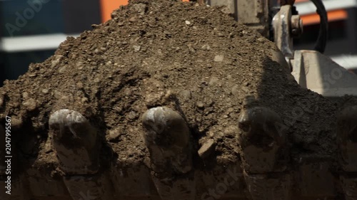 Excavator Bucket Filled with Soil During Earthmoving Operations