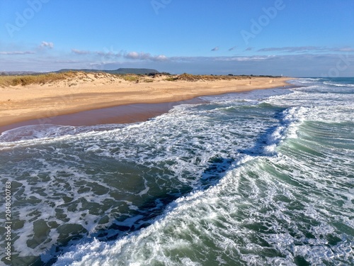Foto low bird's-eye view over a wave running towards the beach, Playa Mangueta betwee