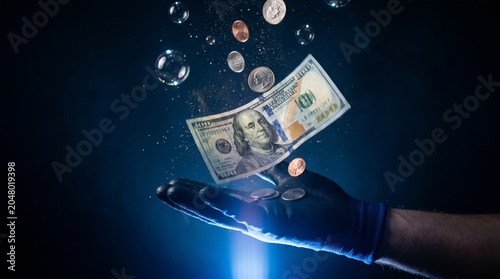 Money floating with bubbles and hand in protective glove