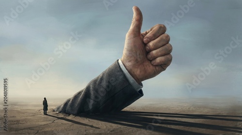 Obraz na płótnie Giant hand giving thumbs up to lone figure in desert