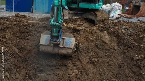 Excavator Grading Excavation Pit on Active Construction Site