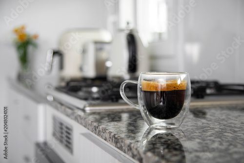 Espresso coffee in double walled glass cup on kitchen counter